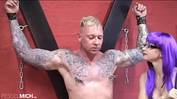 Klammern An Den Brustwarzen Von Muskulösen Devotling Und Das Paddle Auf Den Arsch Von Sexy Domina In Stiefeln